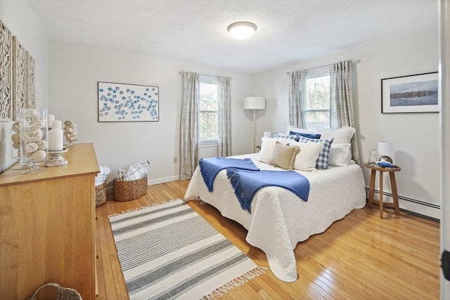 bedroom with hardwood / wood-style flooring and a baseboard radiator