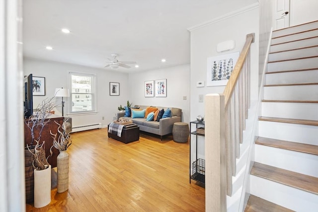 living room featuring crown molding, hardwood / wood-style flooring, ceiling fan, and a baseboard heating unit