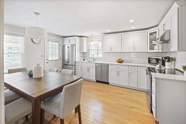 kitchen with sink, pendant lighting, white cabinetry, and appliances with stainless steel finishes