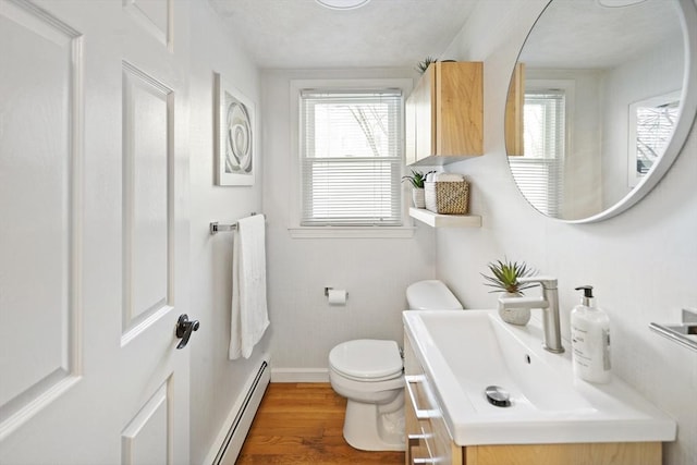 bathroom featuring toilet, hardwood / wood-style floors, a baseboard radiator, and plenty of natural light