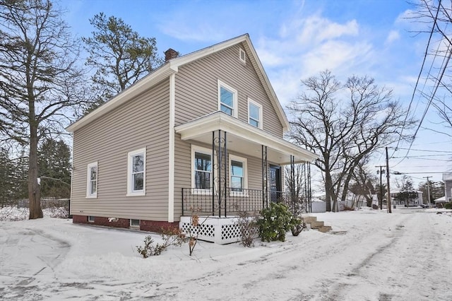 view of snowy exterior featuring a porch