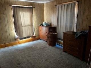 bedroom with carpet flooring and wooden walls