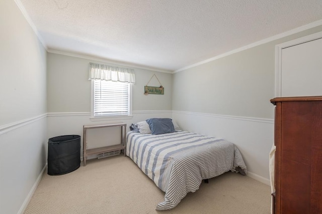 bedroom with baseboards, carpet floors, a textured ceiling, and crown molding