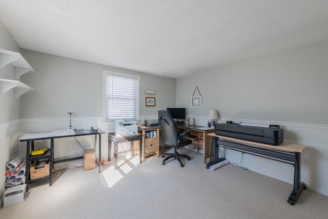 carpeted home office with wainscoting and a textured ceiling