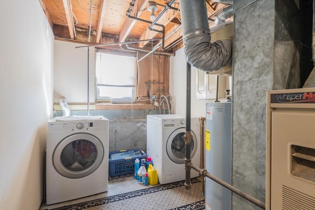 clothes washing area featuring laundry area, water heater, and washer and clothes dryer