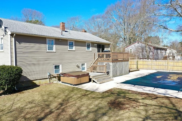 rear view of house featuring a hot tub, fence, a yard, a deck, and a patio area