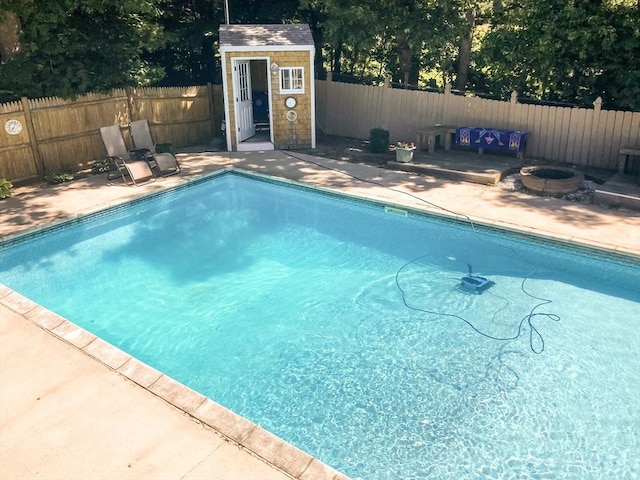 view of pool featuring a patio area, a fenced in pool, an outdoor structure, and a fenced backyard