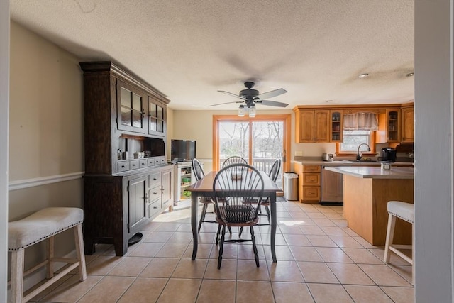 dining space featuring light tile patterned floors, a textured ceiling, and ceiling fan