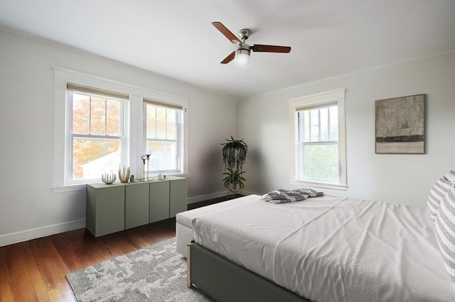 bedroom with a ceiling fan, multiple windows, baseboards, and dark wood-style flooring