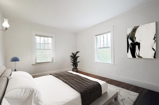 bedroom with dark wood-style floors, multiple windows, and baseboards