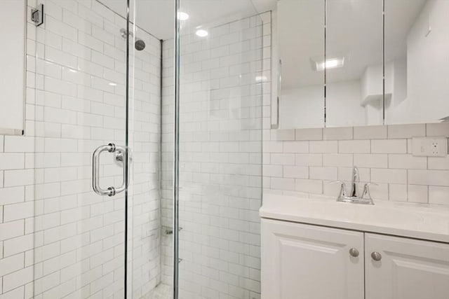 full bathroom featuring a stall shower, vanity, and decorative backsplash