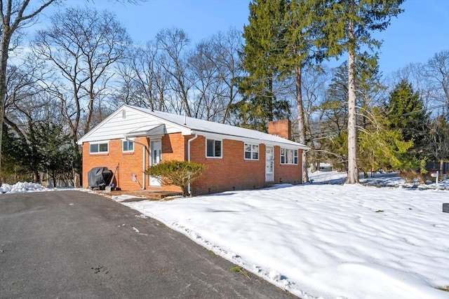 view of front of house with brick siding and a chimney