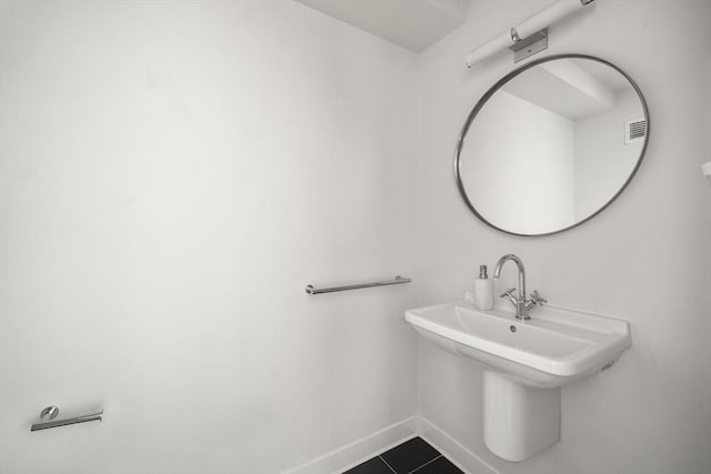 bathroom with baseboards, tile patterned floors, and a sink