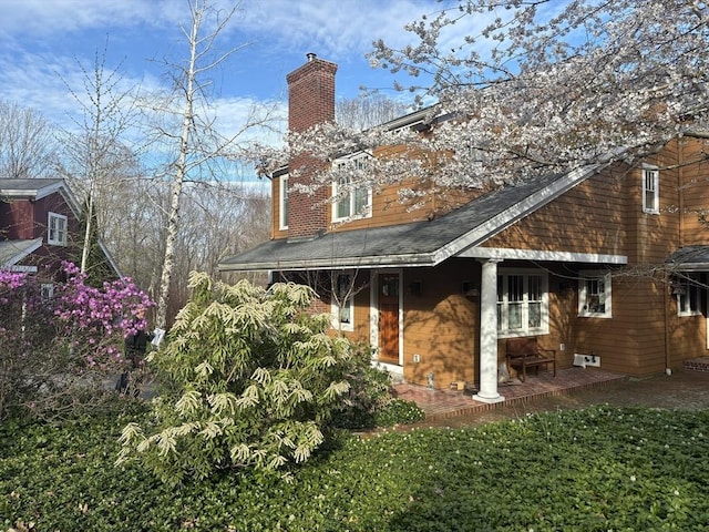 back of house with a chimney