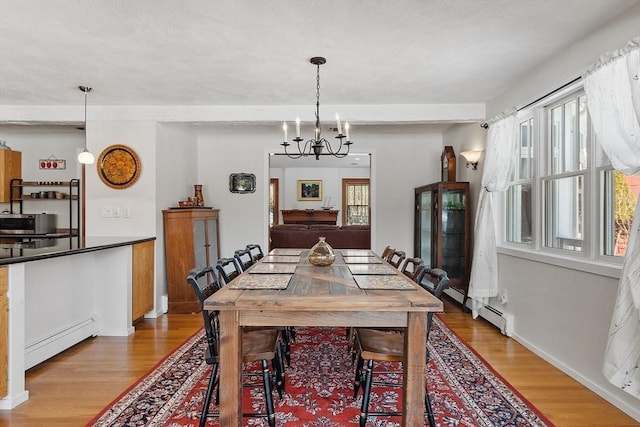 dining room with a baseboard radiator, baseboards, light wood-style floors, baseboard heating, and an inviting chandelier