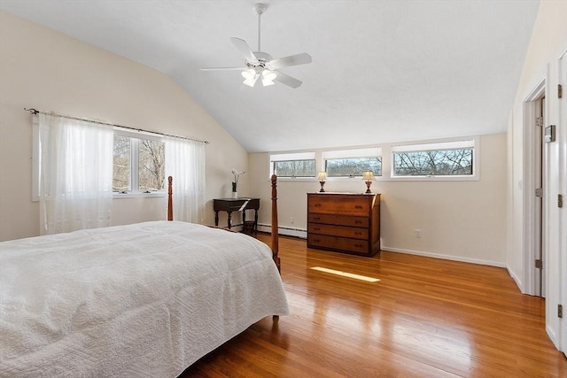 bedroom featuring ceiling fan, a baseboard radiator, wood finished floors, baseboards, and vaulted ceiling