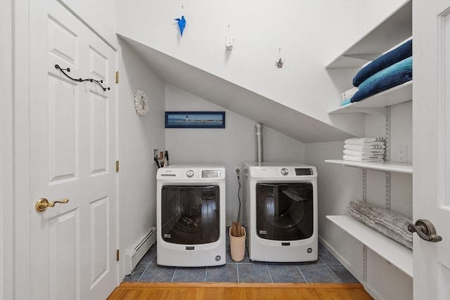 washroom featuring laundry area, tile patterned flooring, baseboard heating, and washing machine and clothes dryer