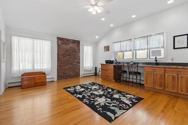 office area featuring lofted ceiling, light wood finished floors, and baseboard heating