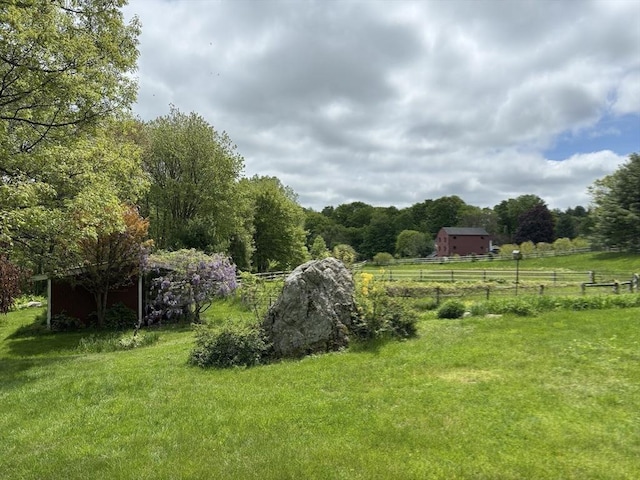 view of yard featuring a rural view and fence