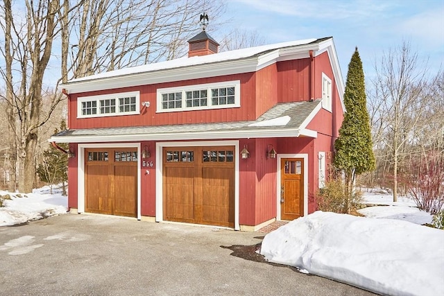 snow covered garage featuring a garage