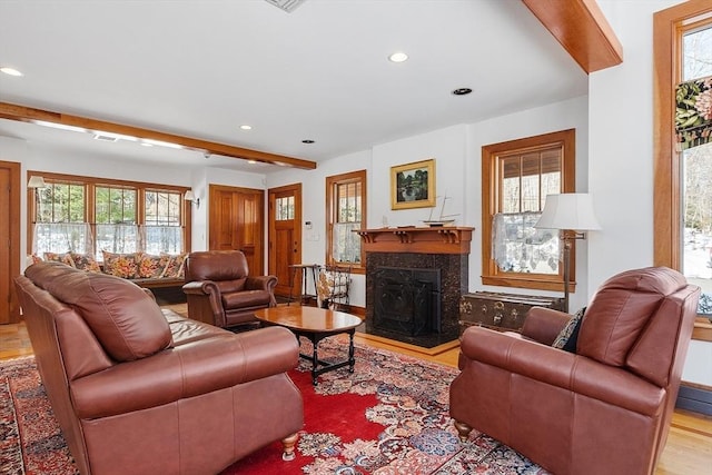 living room with beam ceiling, wood finished floors, a high end fireplace, and recessed lighting