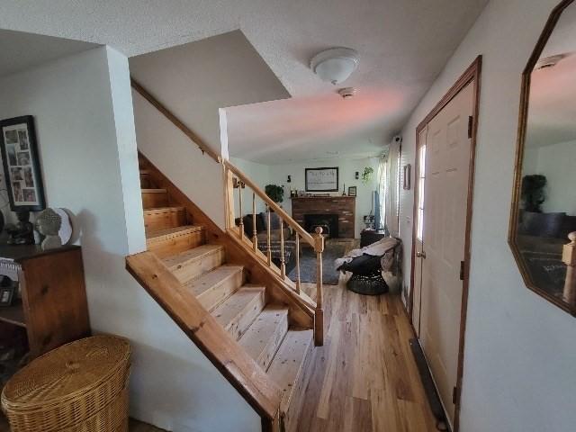 82 Prince Rd, Southbridge, MA 01550 - staircase featuring a brick fireplace and wood finished floors