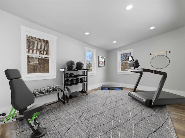 workout area featuring baseboards, vaulted ceiling, wood finished floors, and recessed lighting