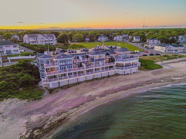 aerial view at dusk with a beach view and a water view