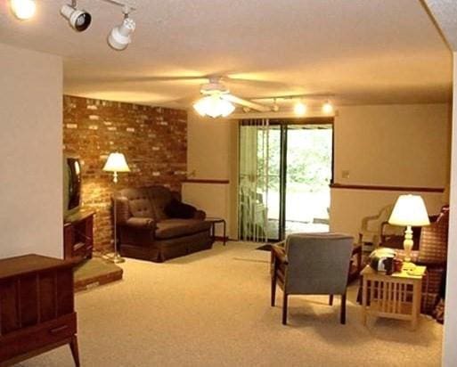 32 Hilltop Ln Unit 2, Easton, MA 02375 - living area with a ceiling fan, carpet floors, rail lighting, and brick wall