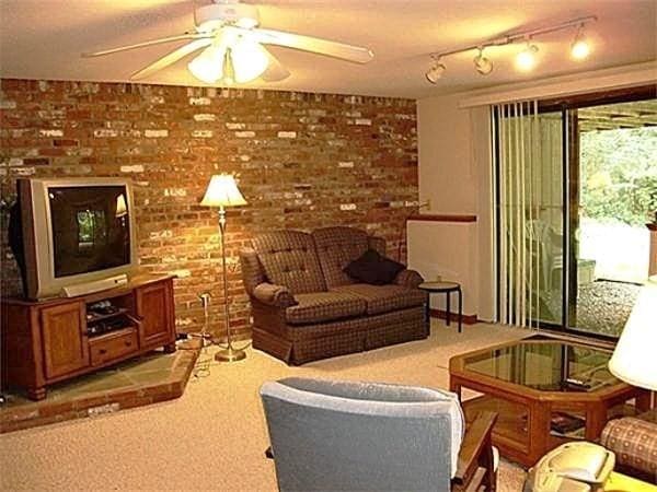 32 Hilltop Ln Unit 2, Easton, MA 02375 - living area with light colored carpet, brick wall, and ceiling fan
