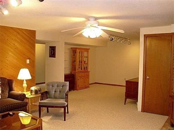 32 Hilltop Ln Unit 2, Easton, MA 02375 - carpeted living area featuring a ceiling fan and wooden walls