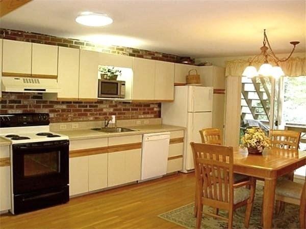 32 Hilltop Ln Unit 2, Easton, MA 02375 - kitchen with white appliances, under cabinet range hood, light countertops, light wood finished floors, and a chandelier