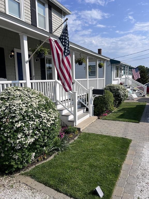 property entrance featuring covered porch and a lawn