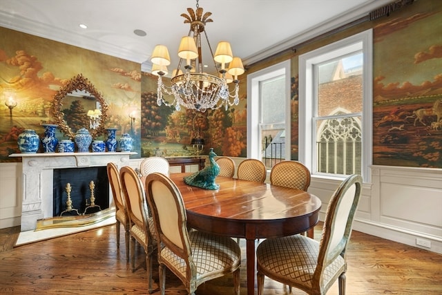 dining room with hardwood / wood-style floors, crown molding, and an inviting chandelier