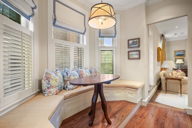 dining space with crown molding, breakfast area, and hardwood / wood-style flooring