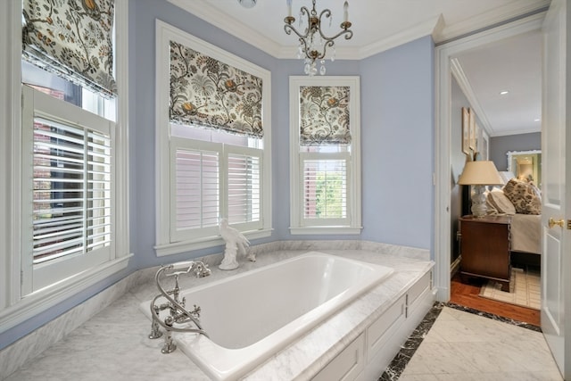 bathroom with ornamental molding, a notable chandelier, and a bathing tub