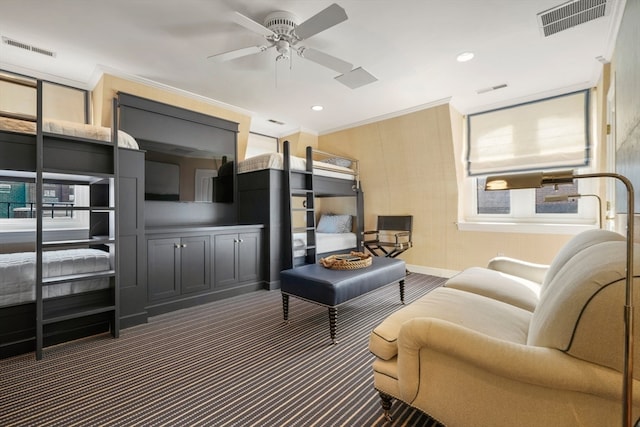 living room with ceiling fan, crown molding, and dark colored carpet