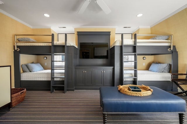 bedroom featuring dark colored carpet, ornamental molding, and ceiling fan