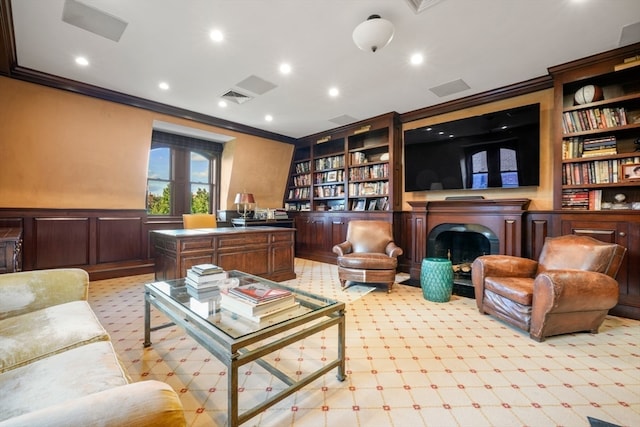 living area with crown molding and built in shelves