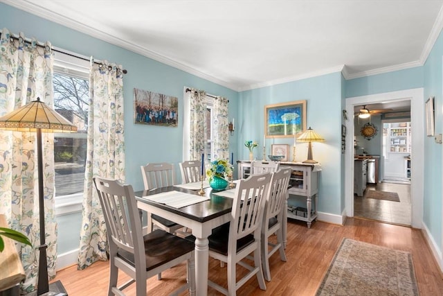 dining room with ornamental molding, wood finished floors, baseboards, and ceiling fan