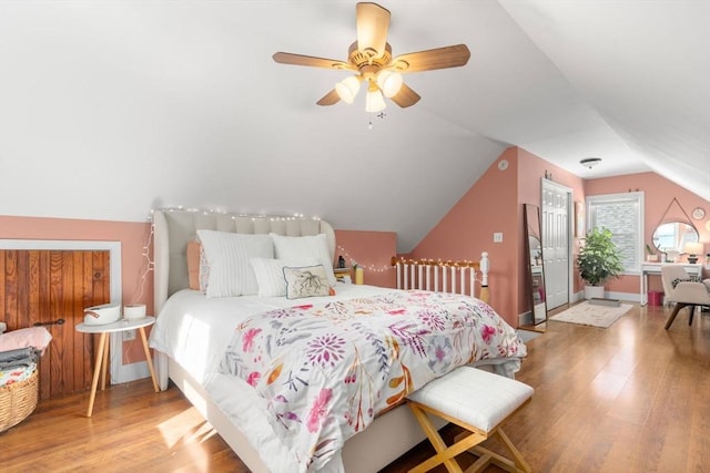 bedroom with wood finished floors, vaulted ceiling, and ceiling fan