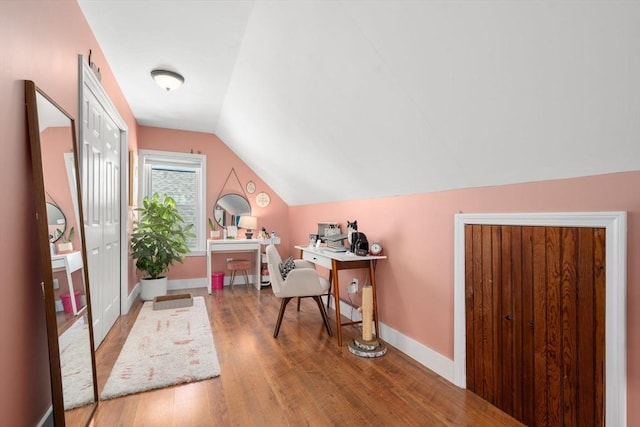 office featuring wood finished floors, lofted ceiling, and baseboards