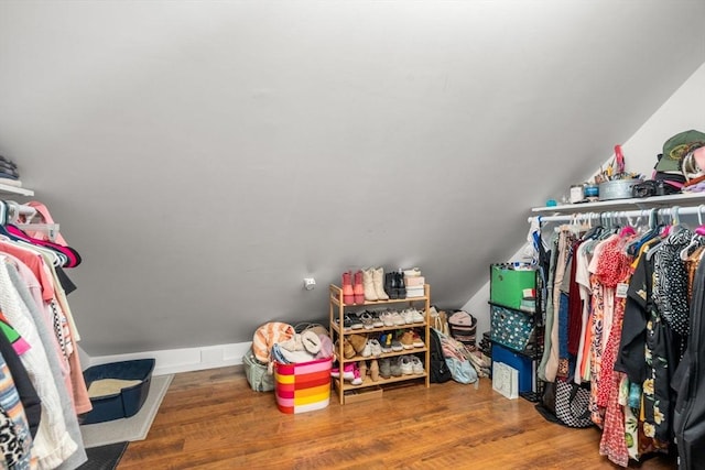 spacious closet with lofted ceiling and wood finished floors
