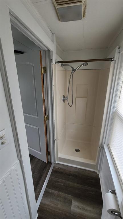 bathroom featuring a shower stall and wood finished floors