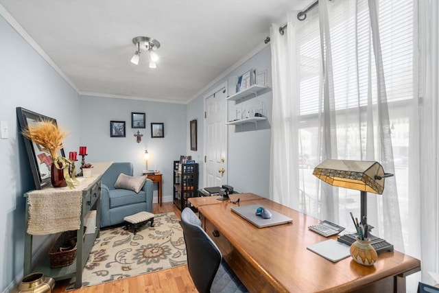 office with crown molding, light wood finished floors, healthy amount of natural light, and baseboards