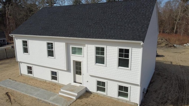 raised ranch featuring roof with shingles