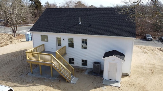 back of house with stairway, central AC unit, a shingled roof, and a deck