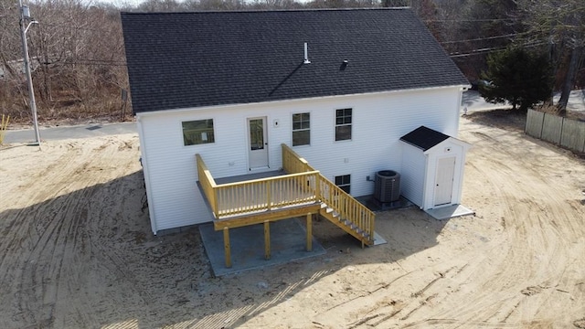 rear view of house with a deck, stairs, central AC, and a shingled roof