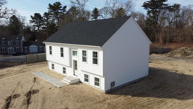 view of front of property featuring a shingled roof and fence