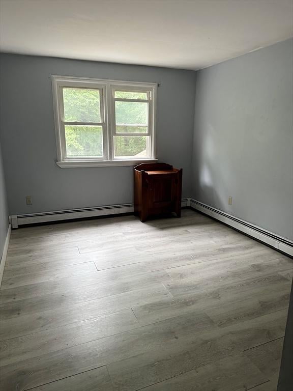 8 Sandy Ln, Pembroke, MA 02359 - empty room with a baseboard radiator and light wood-type flooring